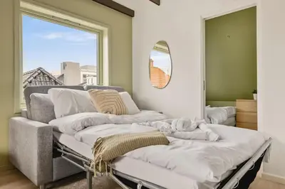 a room with three beds in a room with a window at Dinbnb Appartments l Traditional bergenshouse I Charming I Familiy in Bergen