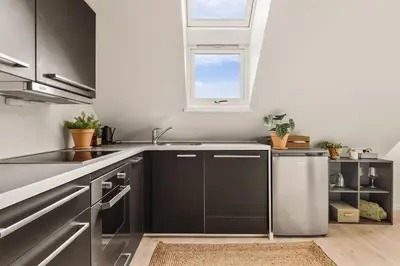 a kitchen with black and white cabinets and a window at Dinbnb Appartments l Traditional bergenshouse I Charming I Familiy in Bergen