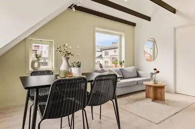 a living room with a table and chairs and a couch at Dinbnb Appartments l Traditional bergenshouse I Charming I Familiy in Bergen