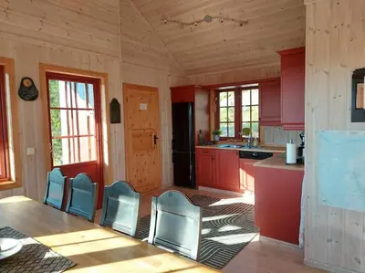 a kitchen with red cabinets and blue chairs at Høyfjellshytte in Flå