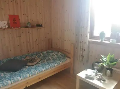 a small bed in a wooden room with a table at Høyfjellshytte in Flå