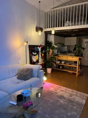a living room with a white couch and a glass table at Top Floor Apartment Trondheim in Trondheim