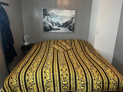 a bed in a bedroom with a painting on the wall at Chalet with amazing fjord view in Lingåsen in Valldal