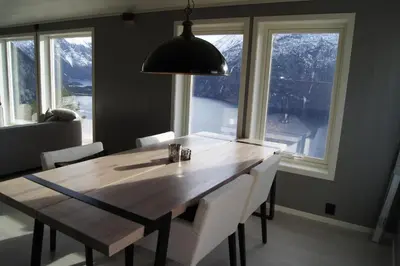a dining room table with white chairs and a large window at Chalet with amazing fjord view in Lingåsen in Valldal
