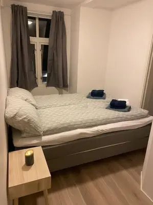 a bed with two towels on it in a bedroom at 2 Bedroom Apartment Located Downtown Trondheim in Trondheim