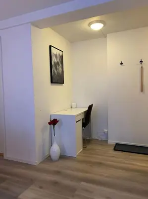 a room with a desk and a vase with a flower in it at 2 Bedroom Apartment Located Downtown Trondheim in Trondheim