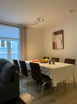 a dining room with a table and chairs and a couch at 2 Bedroom Apartment Located Downtown Trondheim in Trondheim