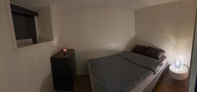 a small bedroom with a bed and a television at Vassfjellet Home in Trondheim