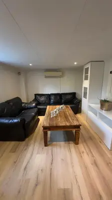 a living room with a leather couch and a coffee table at Vassfjellet Home in Trondheim