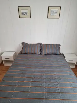 a bed in a room with two night stands and two pictures at Central 2 bedroom apartment in Lillehammer