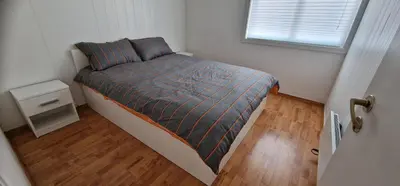 a small bed in a small room with a window at Central 2 bedroom apartment in Lillehammer