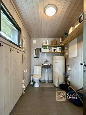 a small bathroom with a toilet and a sink at Modern cabin Skeikampen with ski-in out cross country trails & great view in Aulstad