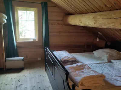 a bedroom with two beds in a log cabin at Coazy cabin with sauna in Trysil