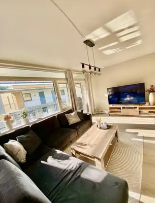 a living room with a couch and a tv at Lægdgrinda 11 in Trondheim