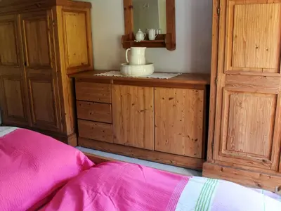 a bedroom with a dresser and a mirror and a bed at 7 person holiday home in VÅGLAND in Vågland