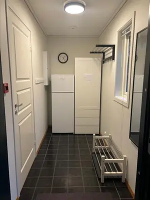 a hallway with a door and a clock on the wall at Røldal a home with a view in Håra