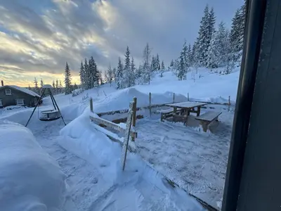a snow covered yard with a picnic table in the snow at Ny moderne hytte i Aust-Torpa in Aust-Torpa