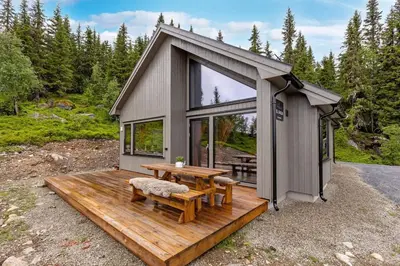 a tiny house with a table and a bench at Ny moderne hytte i Aust-Torpa in Aust-Torpa