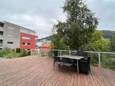 a table and chairs sitting on a wooden deck at Bendixens vei 57 in Bergen