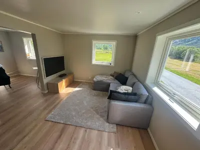 a living room with a couch and a flat screen tv at Hus i Syvde in Sylte