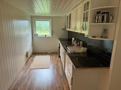 a kitchen with a counter and a sink and a window at Hus i Syvde in Sylte