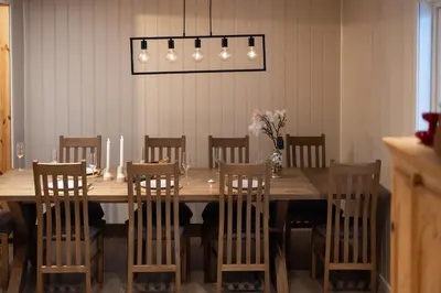 a dining room table with chairs and a vase of flowers at Skoglund privat Villa in Trysil
