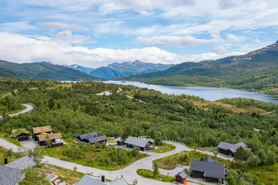 an aerial view of a village with a lake and mountains at Moderne hytte på Fjellsætra med Jacuzzi in Sykkylven