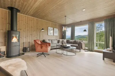 a living room with a couch and a fireplace at Moderne hytte på Fjellsætra med Jacuzzi in Sykkylven