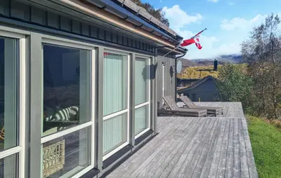 a wooden deck with sliding glass doors on a house at 3 Bedroom Awesome Home In Nordfjordeid in Nordfjordeid