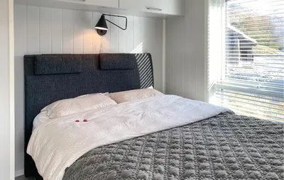 a bed in a bedroom with a large window at 3 Bedroom Awesome Home In Nordfjordeid in Nordfjordeid