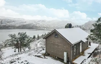 a small building with snow on top of a mountain at 2 Bedroom Lovely Home In Bjordal in Hogvær