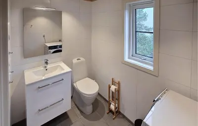 a white bathroom with a toilet and a sink at 2 Bedroom Lovely Home In Bjordal in Hogvær