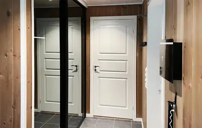 a hallway with two white doors and a television at Amazing Home In Oppdal in Oppdal
