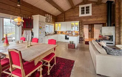 a kitchen and living room with a large wooden table at Awesome Home In Sjusjøen With Sauna in Sjusjøen