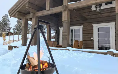 a fire pit in front of a log cabin at Awesome Home In Sjusjøen With Sauna in Sjusjøen