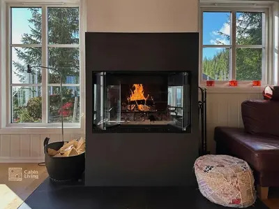 a fireplace in a living room with a fire in it at Luxury cabin Sjusjøen with hot tub, ski in-out, fireplace & WiFi in Ringsaker