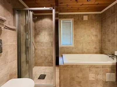 a bathroom with a shower and a tub and a toilet at Luxury cabin Sjusjøen with hot tub, ski in-out, fireplace & WiFi in Ringsaker