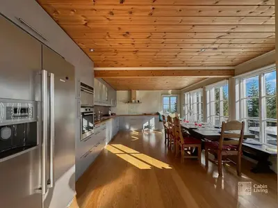 a kitchen with a dining room table with chairs and a kitchen with at Luxury cabin Sjusjøen with hot tub, ski in-out, fireplace & WiFi in Ringsaker
