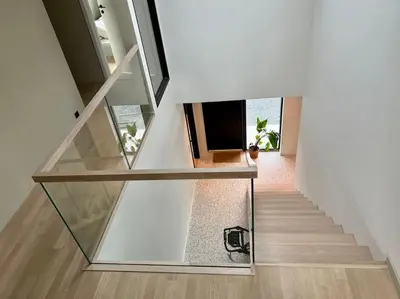 a staircase with a glass railing in a house at Unik funkisbolig leies ut til ski-VM in Lund