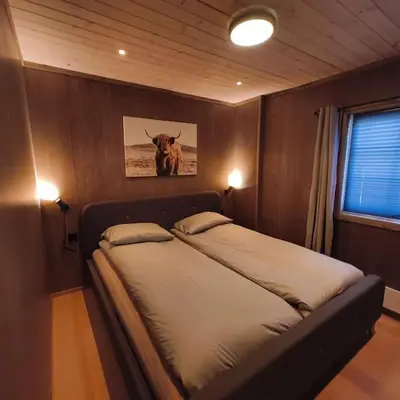 a bedroom with a bed with a picture of a cow at OlaHytta - Cozy cabin close to kvitfjell in Tromsnes