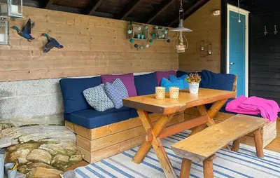 a picnic table and a blue couch on a patio at 4 Bedroom Nice Home In Deknepollen in Måløy