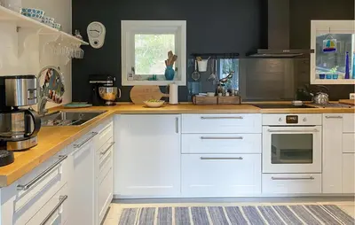 a kitchen with white cabinets and a counter top at 4 Bedroom Nice Home In Deknepollen in Måløy