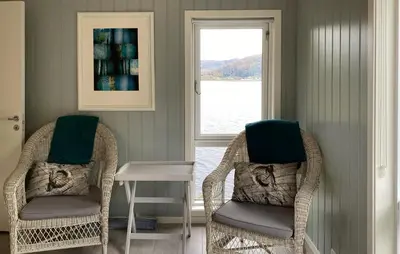 two chairs and a table in a room with a window at 4 Bedroom Nice Home In Deknepollen in Måløy