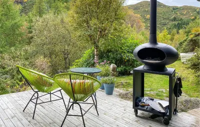 a patio with a stove and two chairs and a table at 4 Bedroom Nice Home In Deknepollen in Måløy