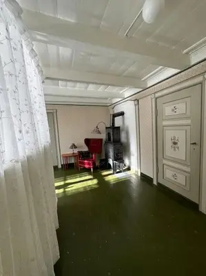 a room with a white curtain and a room with a table at Nyrestaurert hus fra 1700-tallet in Bjørgo