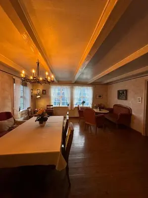 a living room with a table and chairs and a ceiling at Nyrestaurert hus fra 1700-tallet in Bjørgo