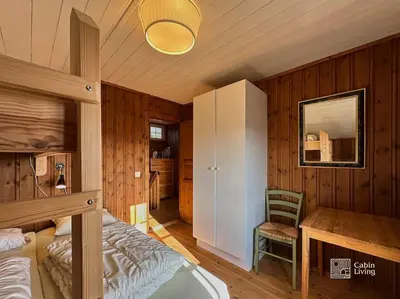 a bedroom with a bed and a desk and a cabinet at Original Olympic cabin ski in out Hafjell in Hunder