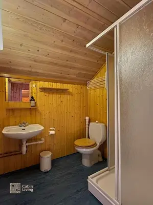 a wooden bathroom with a toilet and a sink at Original Olympic cabin ski in out Hafjell in Hunder