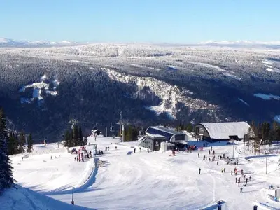 a group of people on a snow covered ski slope at Original Olympic cabin ski in out Hafjell in Hunder