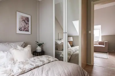 a bedroom with a bed and a mirror at Super Central renovated flat, next to Solsiden, Free Private Parking right outside ! in Trondheim